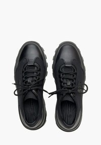 Černé sportovní boty se směsí hladké kůže a texturovaného materiálu, zaoblenou špičkou, šněrovacím designem a kontrastní podrážkou.