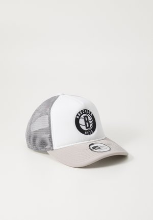 Trucker cap with a white front, gray mesh back, and a beige brim. Features a black circular logo with "BROOKLYN NETS" text. Textured fabric.
