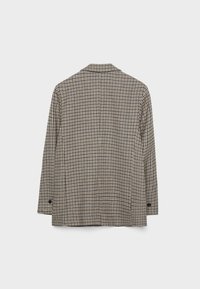 Blazer à carreaux marron et beige avec manches longues, col pointu, poignets à un bouton et fente au dos pour faciliter les mouvements.