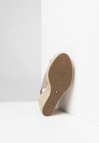 Beige wedge sandal with a textured espadrille sole, featuring a smooth fabric upper and visible logo detail on the outsole. Size 37.