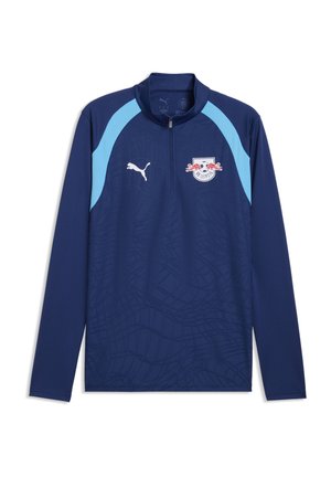 Haut de sport manches longues bleu marine avec des accents bleu clair aux épaules, une fermeture éclair sur le devant, logo Puma et écusson du club de football RB Leipzig.