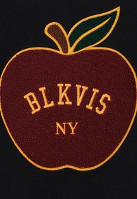 Gráfico de maçã cor de vinho com superfície texturizada, bordado amarelo com a inscrição "BLKVIS NY", sobre um fundo preto; detalhe de folha verde.