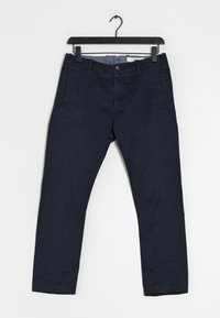 Námořnické modré bavlněné kalhoty se střihem rovné nohy, obsahující boční kapsy a zipový uzávěr. Hladká textura s minimalistickým vzhledem.