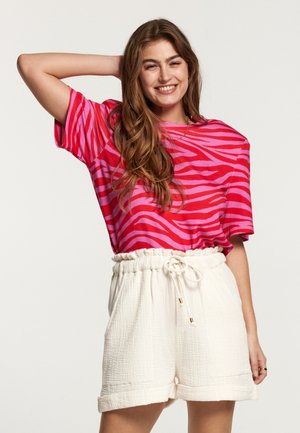 Roze en rode gestreepte t-shirt met korte mouwen, gecombineerd met witte textuur shorts met een elastische tailleband en koordje.