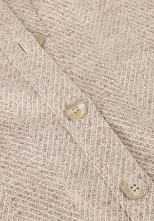 Beige textielstof met een visgraatpatroon, voorzien van pailletten en twee lichte, ronde knopen. Glad afwerking.
