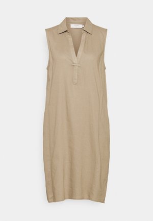 Robe beige sans manches longueur genou avec col et décolleté en V comportant un petit détail de sangle horizontale sous le décolleté.