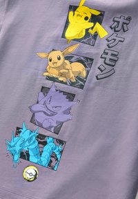 Fialové tričko s postavami Pokémonů: Pikachu (žlutý), Eevee (béžový), Gengar (fialový) a Gyarados (modrý), s grafickými prvky a textem.