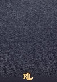 Dunkelblaues strukturiertes Leder mit goldenem RL-Logo-Emblem, zentriert nahe dem unteren Rand.