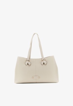 Beige leren totebag met dubbele handvaten, decoratieve goudkleurige accenten en een klein logoplaatje in het midden aan de voorkant.