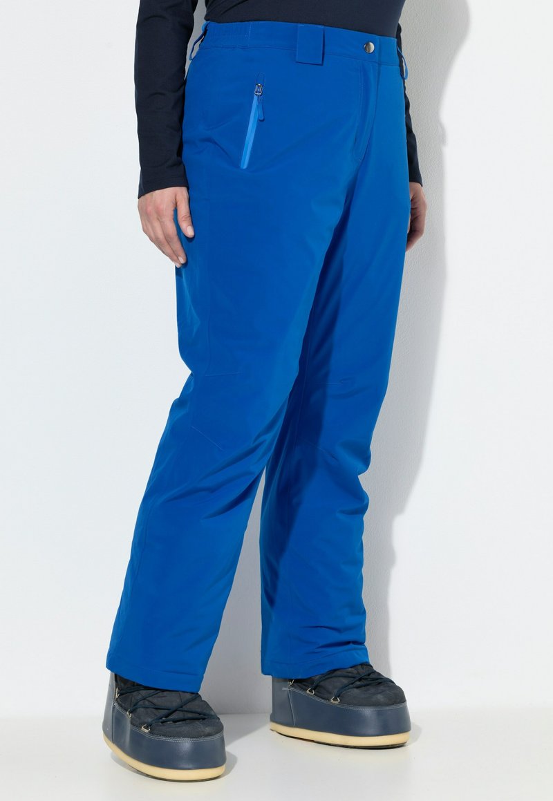 Modré lyžařské kalhoty s rovného střihu, s kapsou na zip a hladkou, voděodolnou látkou. Kombinované s tmavými, zateplenými botami.