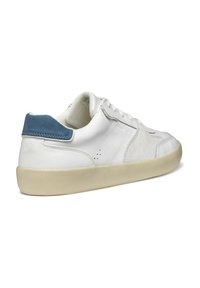 Baskets en cuir blanc avec un accent en suède bleu au niveau du talon, semelle en caoutchouc beige et plate, et détails perforés sur les côtés pour la respirabilité.