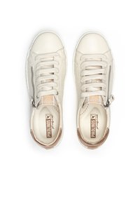 Zapatillas de deporte beige claras con punta redonda, diseño de cordones, cremallera lateral, cuero texturizado y un pequeño acento marrón en el talón.
