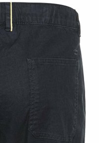 Mørke denim bukser med en baglomme, der har gule syninger ved taljen, glat tekstur og et klassisk lige ben design.
