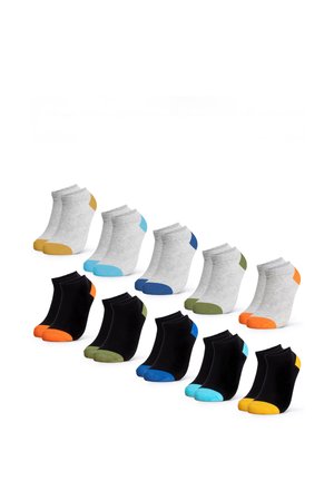 Beine mit schwarzen Knöchelsocken mit hellblauen Zehen, überkreuzt an den Knöcheln, vor weißem Hintergrund.
