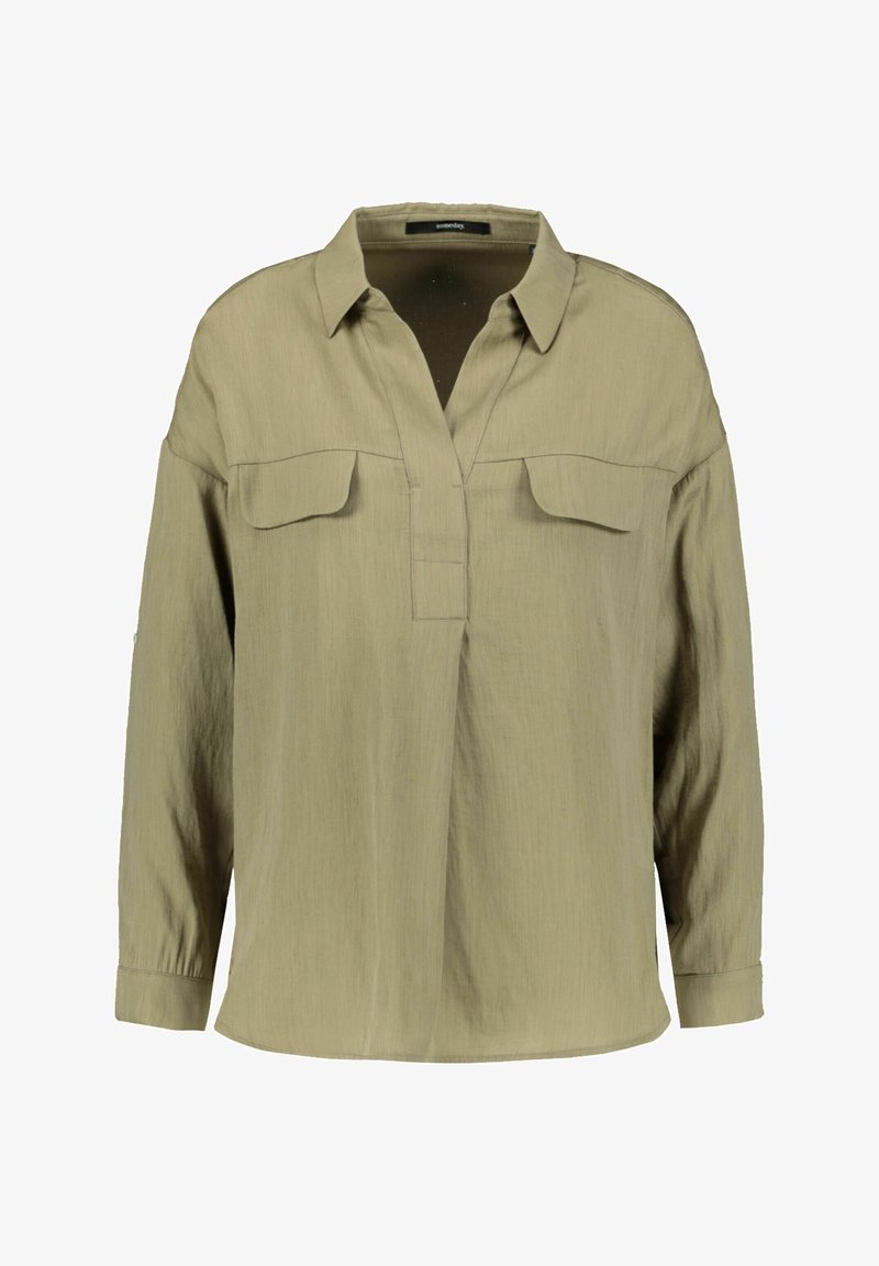 Chemise vert olive clair à manches longues avec col, deux poches poitrine à rabat et une patte de boutonnage avant partiellement ouverte.
