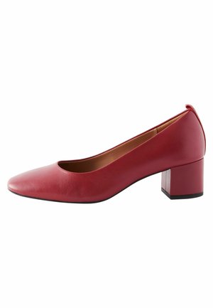 Krev red kožené pumpy na blokovém podpatku s kulatou špičkou, hladkým povrchem a minimalistickým designem. Výška podpatku přibližně 6,5 cm.