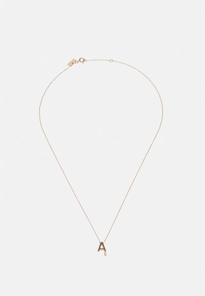 Collana in tono oro con ciondolo a forma di lettera "a" minuscola, catena delicata e una piccola pietra accentata. Design minimalista con texture liscia.