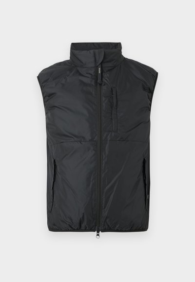 Μαύρο αμάνικο μαξιλαρωμένο γιλέκο με ψηλό γιακά, φερμουάρ μπροστά και τσέπες στο στήθος και στα πλαϊνά με φερμουάρ σε απλό φόντο.