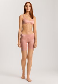 Rosa underklädeset bestående av en bralette med tunna band och matchande shorts i medellängd, tillverkad av ett slätt, strukturerat tyg med blommönster.