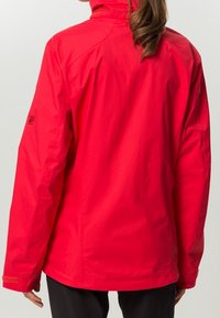 Veste imperméable rouge avec un col montant, une texture lisse et des manches longues. Comprend un logo sur la manche gauche et un ourlet droit.