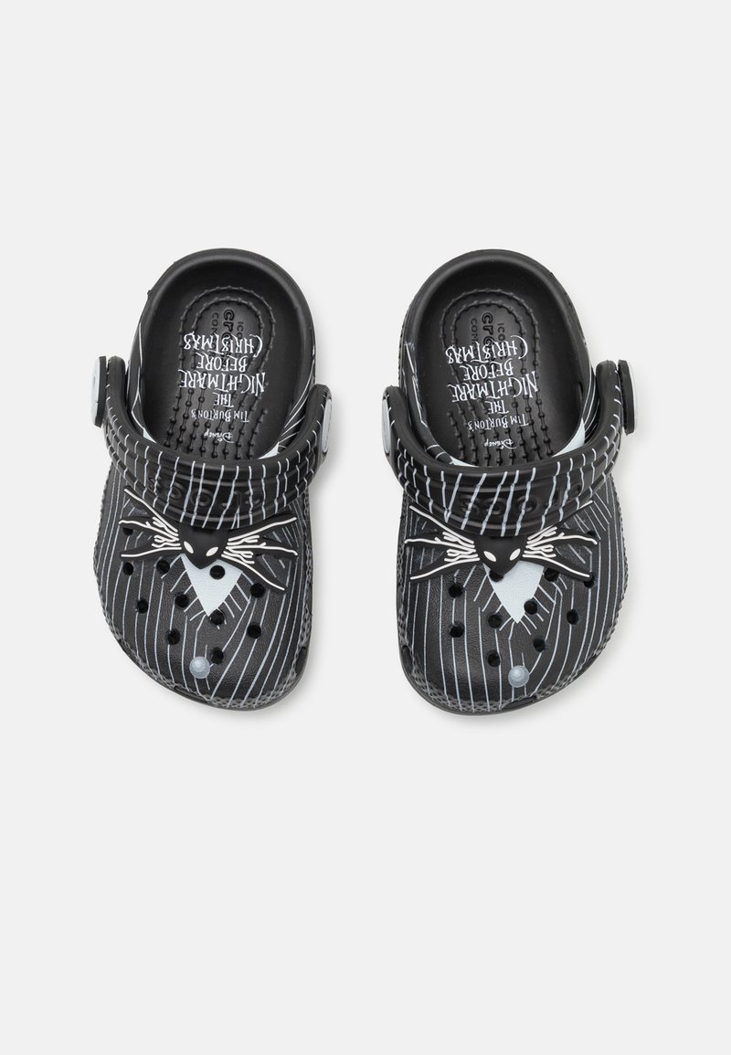 Black plastic clogs with white pinstripe design. Features a character face with whiskers. Includes ventilation holes and adjustable strap.
