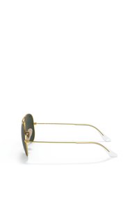 Occhiali da sole in metallo dorato con lenti verdi, inserto nasale regolabile, aste sottili e punte bianche. Design aviator classico con caratteristiche minimaliste.