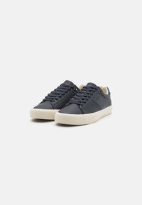 Donkerblauwe lage sneakers met een gladleren bovenwerk, contrasterende crèmekleurige rubberen zool, vetersluiting en subtiele branding op de tong.