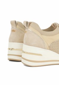 Beige suède platform sneakers met een textuur van mesh bovenwerk, elastische boorden en accenten in goudkleur. Dikke witte zool met beige strepen.