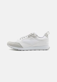 Baskets blanches de sport avec des accents en suede gris, des panneaux texturés, des lacets et une semelle rembourrée. Logo affiché sur le côté.