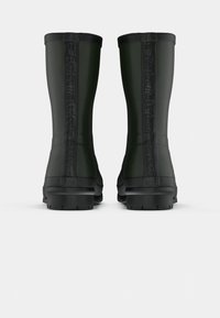 Bottes de pluie en caoutchouc noires avec une finition texturée et un logo en relief audacieux au dos. Semelle épaisse pour une meilleure traction. Hauteur moyenne.