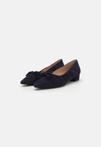 Pantofole basse in suede blu navy con punta affusolata e dettaglio a fiocco sulla parte anteriore. Texture liscia e colore uniforme in tutto.