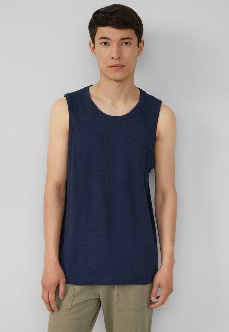 Marineblauwe mouwloze tanktop met een ronde halslijn, gemaakt van zacht materiaal. Heeft een subtiele logo op de borst en een relaxte pasvorm.