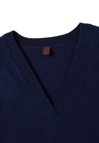 Navyblauwe v-hals trui met geribde halslijn en manchetten, gemaakt van zacht materiaal, met een label in rood en wit op de binnenkant van de kraag.