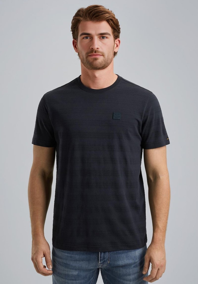 Camiseta de manga corta a rayas en azul marino, fabricada en algodón. Cuenta con un escote redondo y un pequeño parche de logo en el pecho. Ajuste clásico.