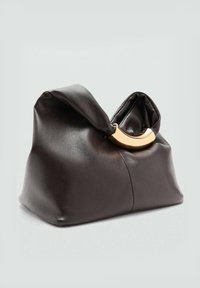 Sac en cuir marron au format doux et froissé. Présente un accent en métal doré en forme de cercle. Texture lisse avec des plis remarquables.