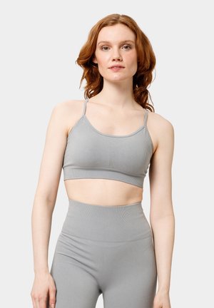 Grijze geribde bralette met dunne bandjes, cropped ontwerp en naadloze textuur. Gecombineerd met hoge grijze leggings in een bijpassende stijl.