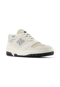 Scarpe da ginnastica beige e bianche con tomaia testurizzata, caratterizzate da un logo grigio, lacci piatti e suola in gomma nera con battistrada decorato.