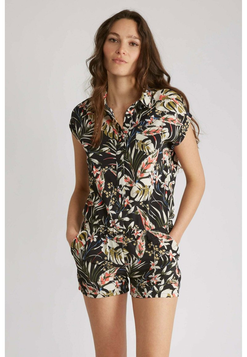 Une combinaison florale en tissu noir avec des manches courtes, un col, des poches et une taille cintrée. Le design comprend des motifs tropicaux vibrants.