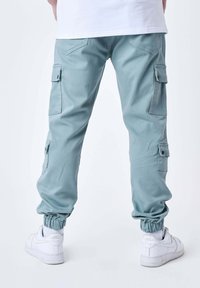 Lichtblauwe cargo broeken met elastische boorden, zijzakken en een ontspannen pasvorm. Gemaakt van zacht materiaal, ontworpen voor comfort en functionaliteit.