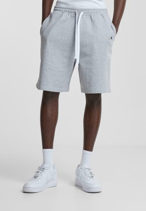 Graue Sweatshorts aus einem Baumwollmischgewebe mit elastischem Bund und weißem Kordelzug. Mit seitlichen Taschen und einem kleinen Logodetail.