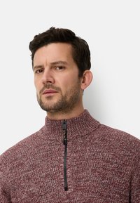 Bordeauxrode sweater met ritssluiting, hoge kraag, textuurgebreid ontwerp en zwarte rits. Kenmerkt zich door een duurzaam materiaal en een casual silhouet.