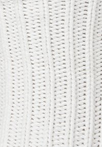 White woven textile with vertical stripes and varying textures, featuring a consistent pattern of intertwined fibers.