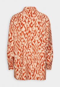 Chemise à manches longues avec imprimé animal abstrait rouge et crème, dotée d'un col classique et d'une coupe ample, vue de dos.