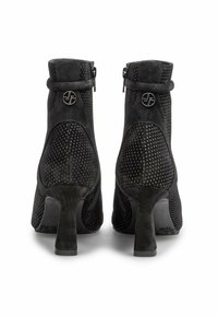 Botines de ante negro con un diseño perforado, cierre de cremallera y un tacón bloque de altura media. Presenta un emblema circular en la parte trasera.