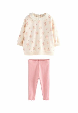 Felpa crema con stampa floreale e collare in pizzo, abbinata a leggings rigati rosa chiaro con orlo scalloppato.