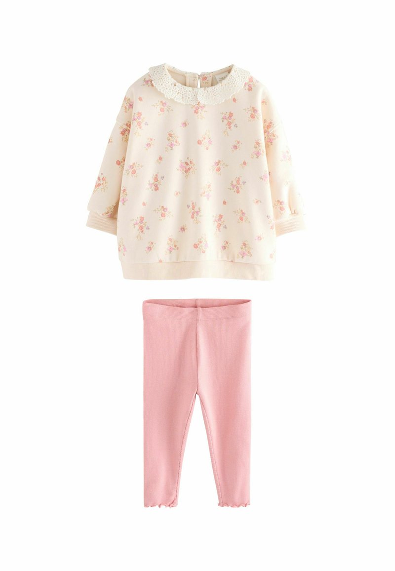 Felpa crema con stampa floreale e collare in pizzo, abbinata a leggings rigati rosa chiaro con orlo scalloppato.