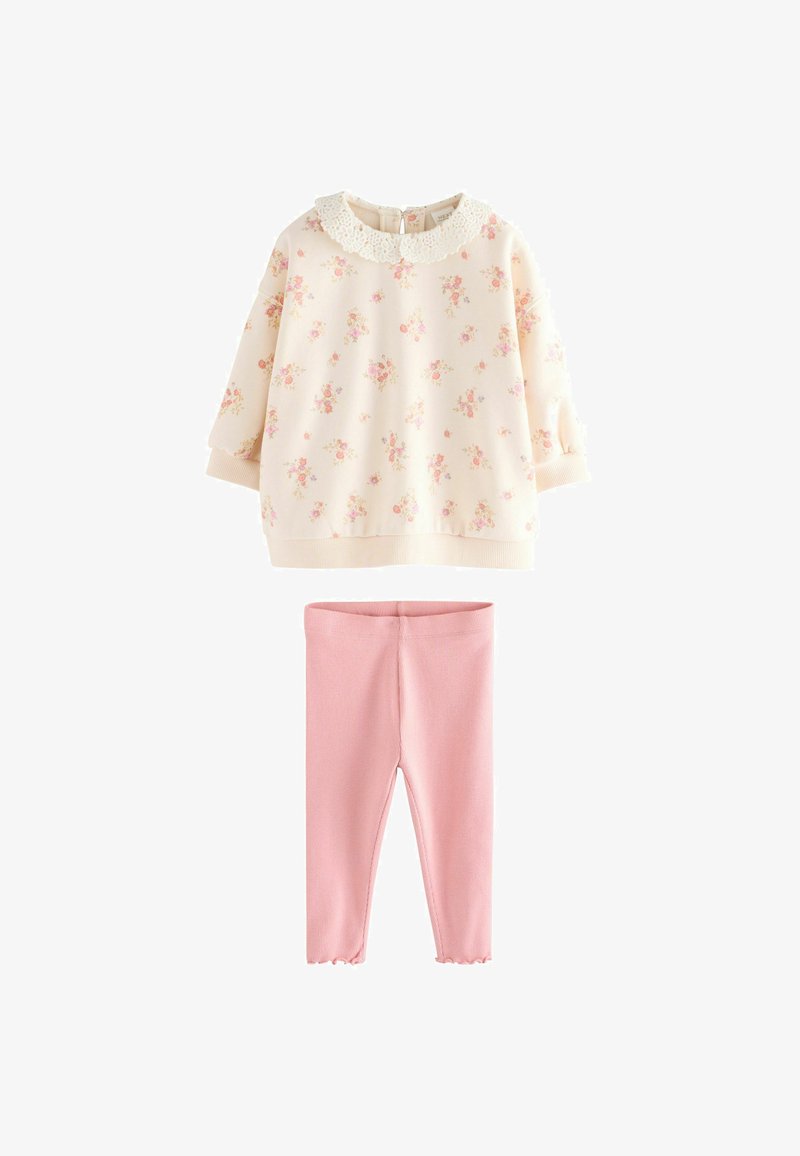 Krem hudica s cvjetnim printom i čipkastim ovratnikom, u kombinaciji s laganim ružičastim rebrastim tajicama s obrubljenim rubovima.