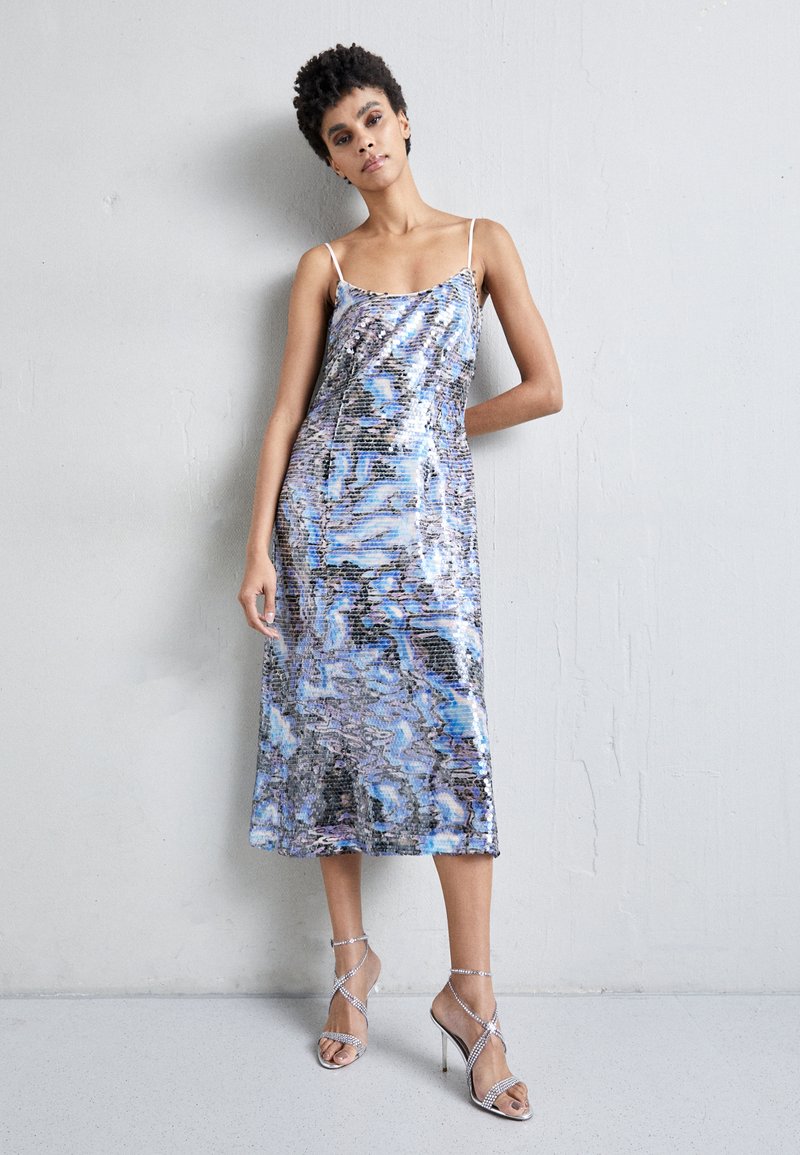 Rochie din paiete strălucitoare, cu lungime midi, având un model multicolor în nuanțe de albastru, argintiu și negru. Are bretele subțiri.