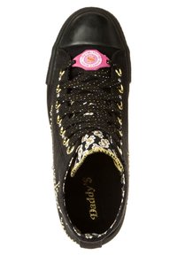 Baskets montantes noires avec œillets dorés, lacets noirs à pois, languette à motif floral et logo circulaire rose près du haut.