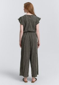 Gestreepte jumpsuit met korte gerimpelde mouwen, een getailleerde taille en wijde broekspijpen, in een zwart-wit kleurenschema. Sleutelgatdetail aan de achterkant.